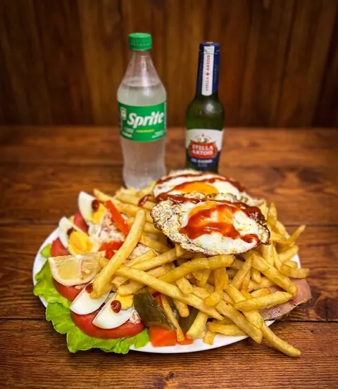 Chivito al plato con huevos fritos, papas fritas, huevo duro, tomate y lechuga