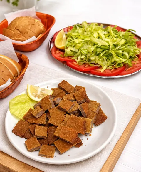 Milanesa picada al limón con ensalada de lechuga y tomate y pan